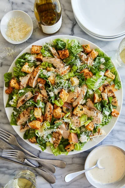Bowl of chicken Caesar salad with sliced chicken, romaine, croutons and parmesan