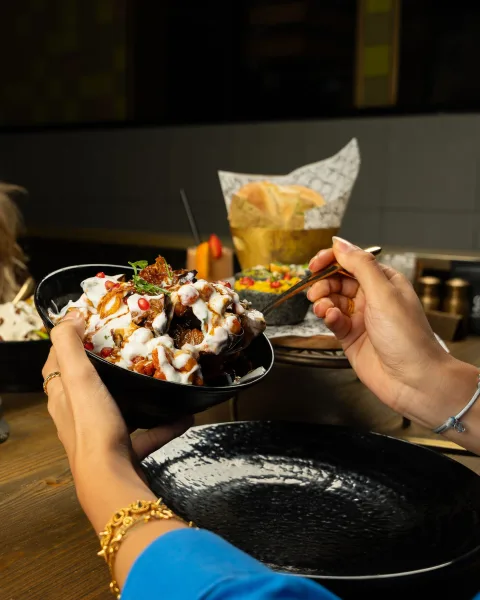 Bowl of Pakistani fruit chaat with apple, guava, grapes, orange, banana and pomegranate topped with mint and chaat masala