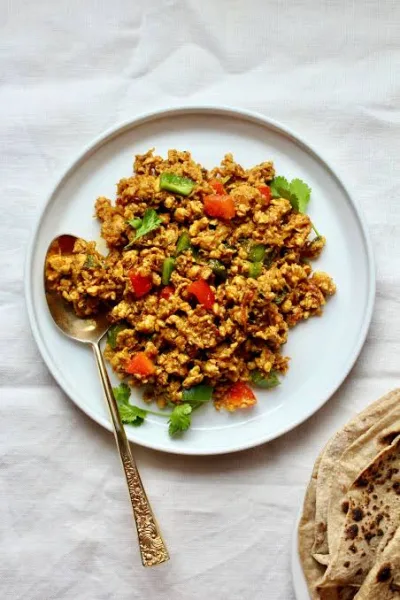 A karahi of spiced beef mince with green capsicum pieces, ginger and fresh coriander, served with rotis